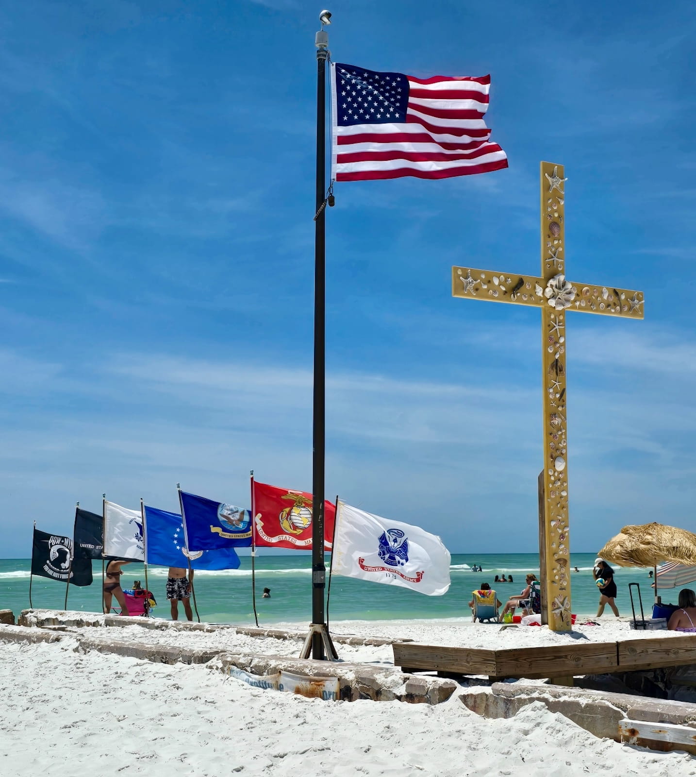 Flag and seashell cross on the beach